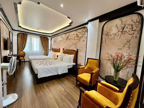 a hotel room with a bed and two chairs at Royal Hotel Hà Nội in Lưu Phái