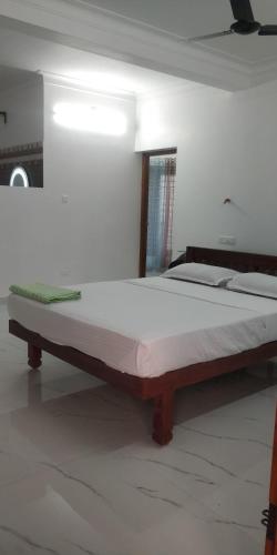a large bed in a white room with at Temple House in Trivandrum