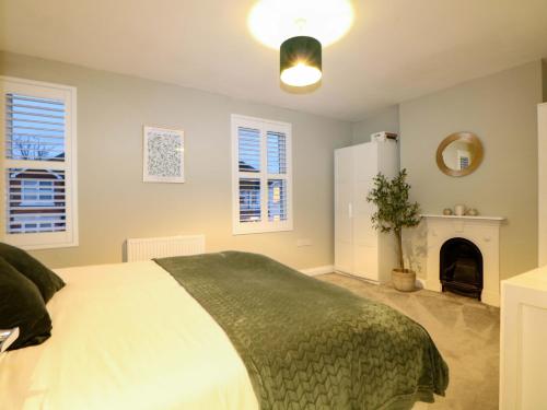 a bedroom with a bed and a fireplace at Gordon Avenue in Camberley
