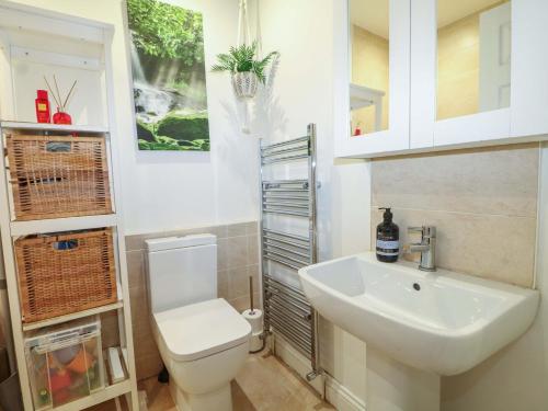 a bathroom with a white toilet and a sink at Gordon Avenue in Camberley