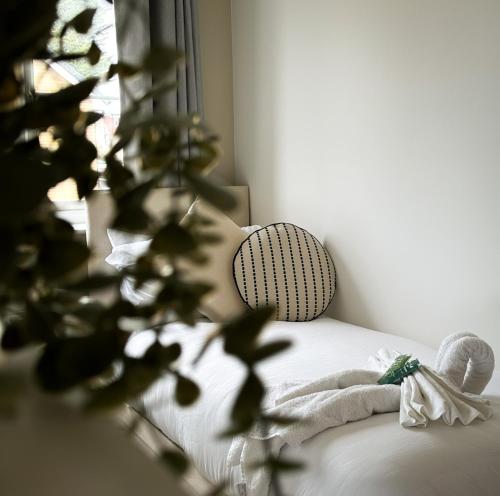 ein Schlafzimmer mit einem Bett mit einer Pflanze und einem Fenster in der Unterkunft Heathrow Home - 4BR - Sleeps 6 - Free Parking - Work and Family Friendly in Stanwell