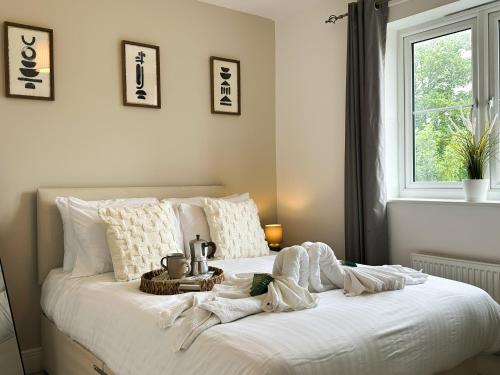 ein weißes Bett mit einem Tablett darauf in der Unterkunft Heathrow Home - 4BR - Sleeps 6 - Free Parking - Work and Family Friendly in Stanwell