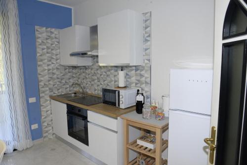 eine Küche mit einer Theke, einer Mikrowelle und einem Kühlschrank in der Unterkunft Il Poeta - casa accogliente tra Amalfi e Cilento in Battipaglia