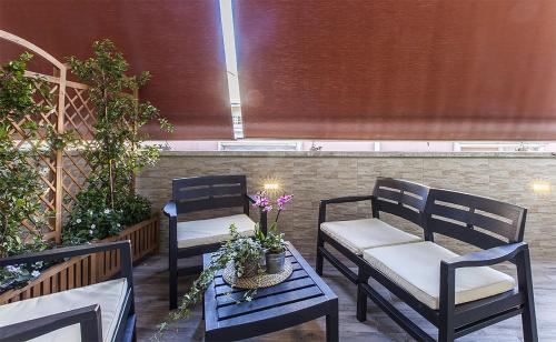 two chairs and a table with flowers on a patio at La Palma in Rome