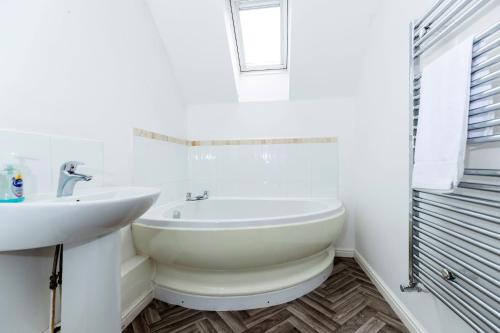 een witte badkamer met een wastafel en een bad bij Spacious 3-Bed Home – Family Contractor Friendly in Coxhoe