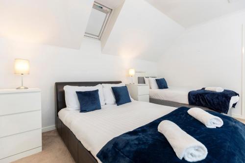 twee bedden in een slaapkamer met blauw en wit bij Spacious 3-Bed Home – Family Contractor Friendly in Coxhoe
