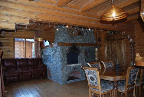 a living room with a stone fireplace and a table at Kraevyd Hotel in Yaremche