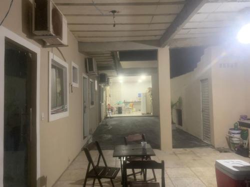 un corridoio con un tavolo e delle sedie in un edificio di Hostel dos amigos a Salinópolis
