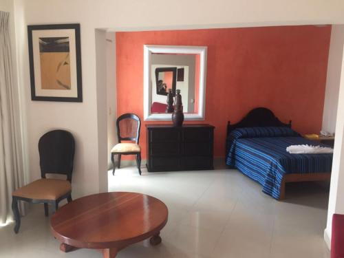 a bedroom with a bed and a table and chair at Casa del Parque Vallarta in Puerto Vallarta