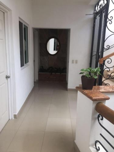 a hallway with white walls and a door and a mirror at Casa del Parque Vallarta in Puerto Vallarta