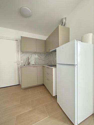 eine Küche mit weißen Geräten und einem weißen Kühlschrank in der Unterkunft Renovated prestige apartment in Aubervilliers