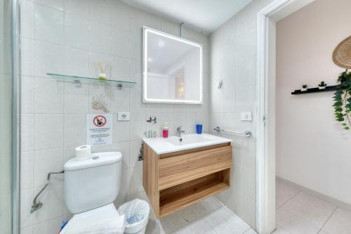 un bagno con un water, un lavandino e uno specchio di SUITE ABORA RELAX a 500m DE LA PLAYA WIFI FIBRA a Puerto del Carmen