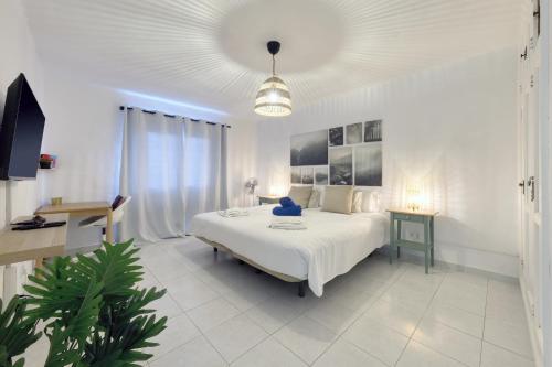 una camera da letto bianca con un letto grande e un tavolo di SUITE ABORA RELAX a 500m DE LA PLAYA WIFI FIBRA a Puerto del Carmen