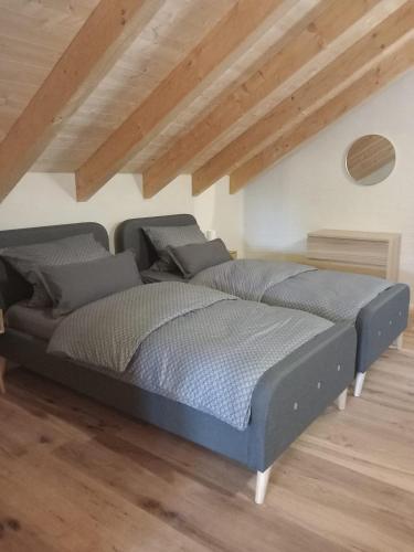 a large bed in a room with wooden floors at Ferienhaus Waldruhe in Hellenthal