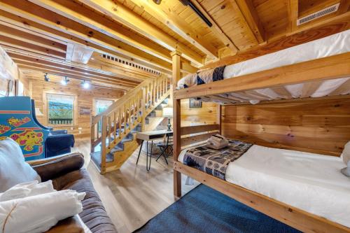 a log cabin bedroom with two bunk beds and a staircase at High Cotton Epic Views Hot Tub Pool Table in Sevierville