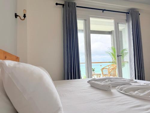 a bedroom with a bed with a view of the ocean at Goalie Beachfront Resort in Hikkaduwa
