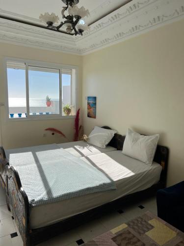 een slaapkamer met een bed in een kamer met een raam bij Blue Beach Apartments in Taghazout