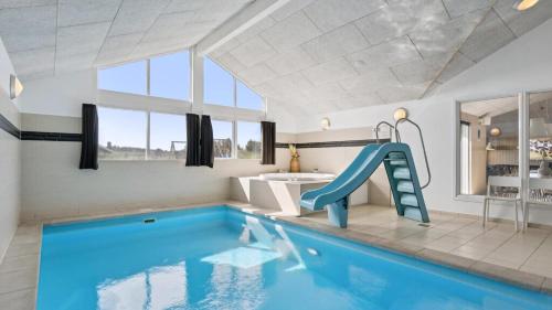 un bagno con una piscina blu e uno scivolo di Villavilla #292 - Søndervig, Vestjylland a Klegod