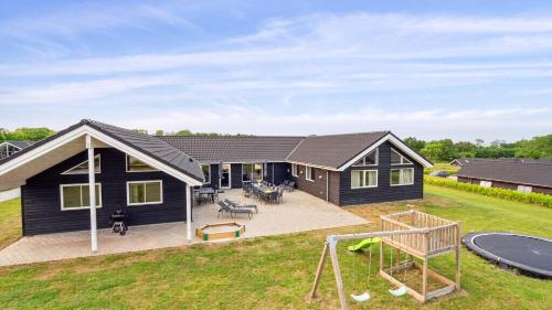 een huis met een speeltuin ervoor bij Villavilla #508 - Mommark, Sydjylland in Sarup