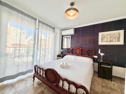 een slaapkamer met een groot bed met twee handdoeken erop bij Macarena House & Chill Out in Benidorm