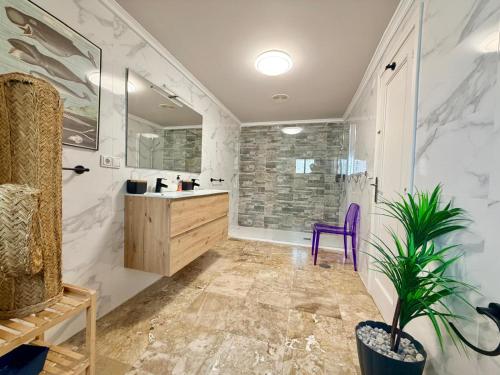 een badkamer met een wastafel, een douche en een paarse stoel bij Macarena House & Chill Out in Benidorm