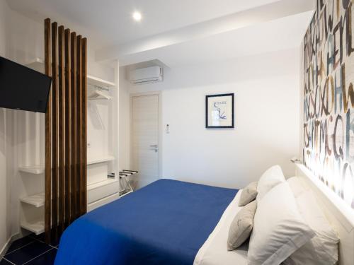 Schlafzimmer mit blauem Bett und weißen Wänden in der Unterkunft VENART by AnrealeRooms in Paestum