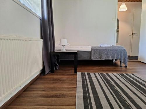 a bedroom with a bed and a table with a lamp at Spacious Apartment for 5 in Sodankylä