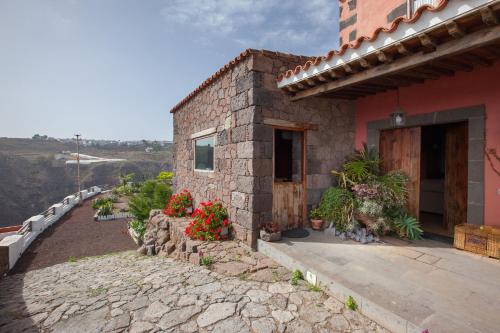 a brick house with flowers in front of it at Mountain Hideaway House in Moya in Moya