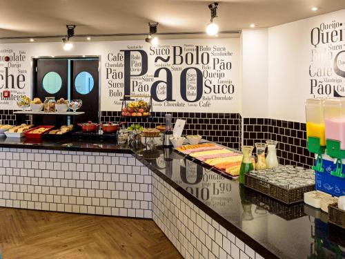 Een buffet in een restaurant met bordjes aan de muur. bij ibis budget SP Centro Sao Joao in Sao Paulo