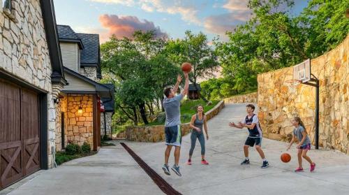 een groep mensen die basketbal spelen op een oprit bij Gather in Style Space Views & Comfort in Runaway Bay