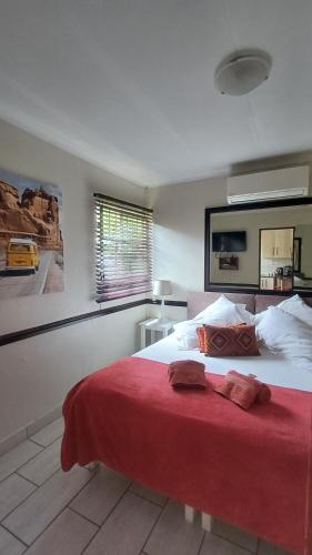 ein Schlafzimmer mit einem großen Bett mit einer roten Decke in der Unterkunft Ceelee's Place in Bloemfontein