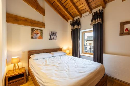 una camera da letto con un letto grande e una finestra di L’Écrin des Angles - Jacuzzi Sauna Hamman privé a Les Angles