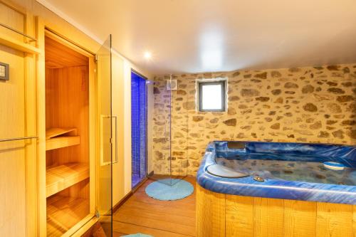 un bagno con una grande vasca in una stanza di L’Écrin des Angles - Jacuzzi Sauna Hamman privé a Les Angles