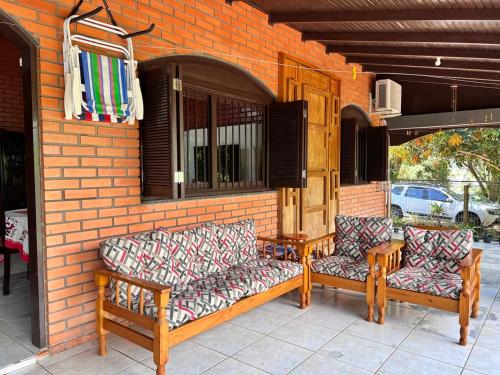 2 sedie e un tavolo su un patio di Casa de Campo Pet Friendly com Churrasqueira a Pitangueiras