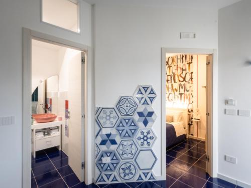 ein Schlafzimmer mit einer blau-weiß gefliesten Wand in der Unterkunft VENART by AnrealeRooms in Paestum