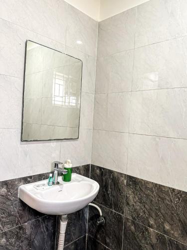 a bathroom with a sink and a mirror at Hotel SAFKO Grand - Hopefarm Metro Whitefield in Bangalore