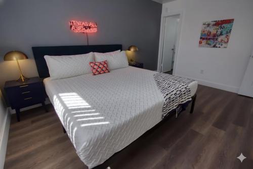 a bedroom with a large bed with a white comforter at 23 Palms Suites - Midtown Wynwood in Miami