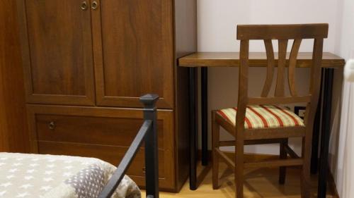a bedroom with a desk and a chair next to a cabinet at B&B Culla Dell'Aquila in LʼAquila