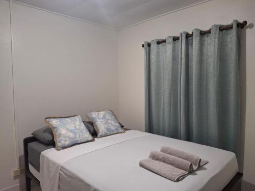 a bed with two towels on it in a bedroom at Pams Lodge Barbados in Christ Church
