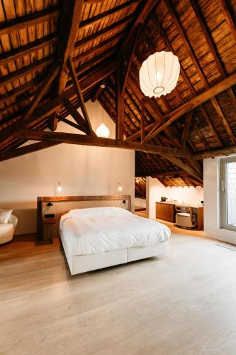 a bedroom with a bed in a room with wooden ceilings at Alfred Hotel & Gastro Bar in Marche-en-Famenne