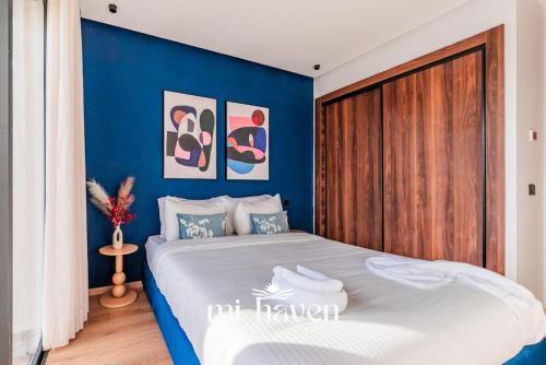 a bedroom with a blue accent wall and a bed at Aura - 1 BR - Premium Apartment in Maarif