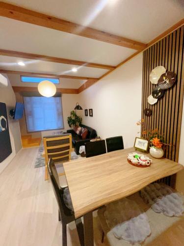 a living room with a wooden table and chairs at SMILE HOUSE close to USJ Mario Kidsroom high class kitchen bath easy to Kobe Nara 10mins to downtown by train up to 6ppl in Osaka