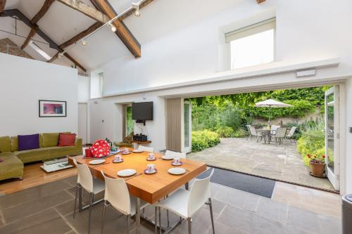 a living room with a wooden table and chairs at The Barn at Noelles Cottages in Pickering