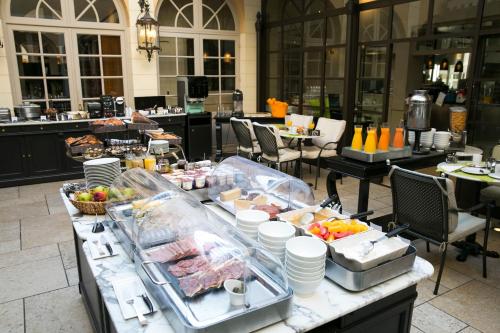a buffet of food on a table in a restaurant at Best Western Premier Grand Monarque Hotel & Spa in Chartres