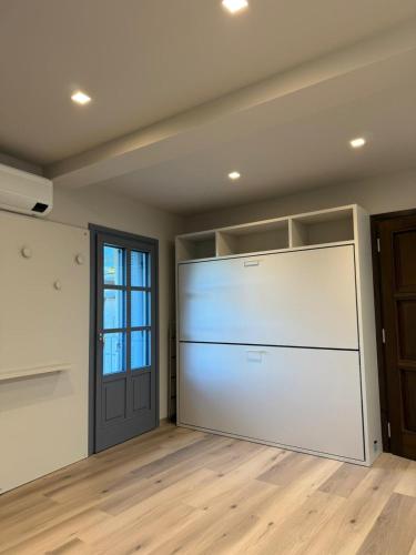 un grande garage bianco con una porta e pavimenti in legno di Lanzo Belvedere - Central Apartment a Lanzo Torinese