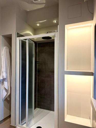 un bagno con doccia con porta in vetro di Lanzo Belvedere - Central Apartment a Lanzo Torinese