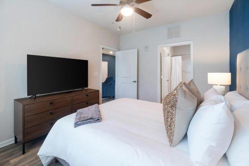 a bedroom with a large white bed with a flat screen tv at Landing Spectacular 1BD Clubhouse Gym in Charlotte