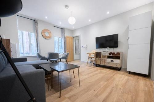 a living room with a couch and a tv at Central Mayfair 1 Bedroom Apartments 33SGG no lift in London