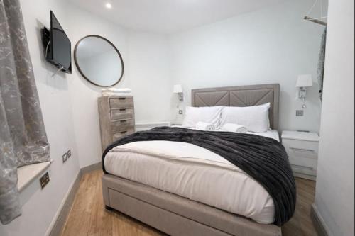 a bedroom with a large bed and a mirror at Central Mayfair 1 Bedroom Apartments 33SGG no lift in London