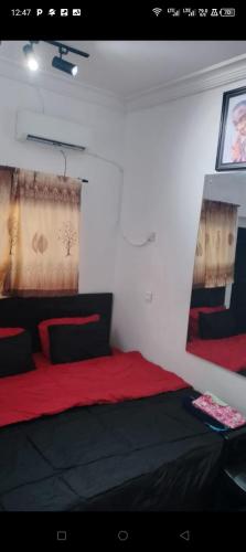 een slaapkamer met een rood en zwart bed in een kamer bij Short Let Apartments in Lagos Business School Lekki Ajah in Lekki